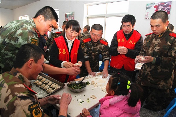 慈善义工和部队官兵一起包饺子喜迎新春